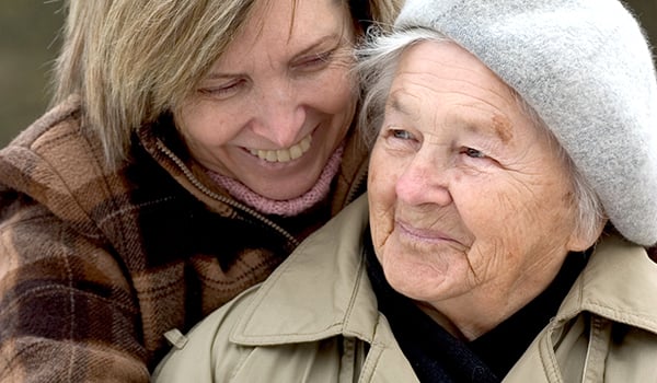 Elderly woman with her carer smiling