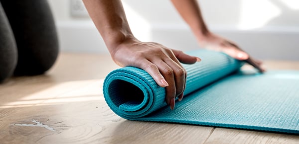 Woman rolling up an exercise mat